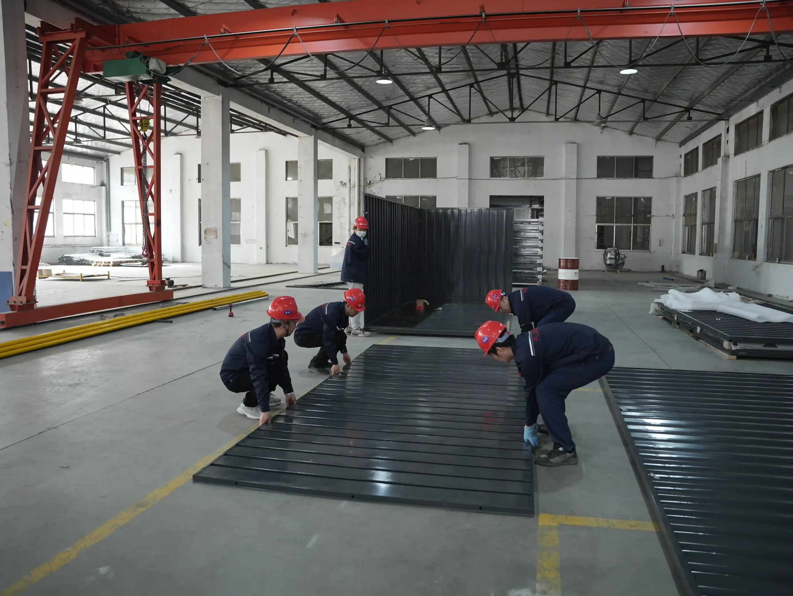 Flatbox team assembling steel panels for a flat-pack storage container