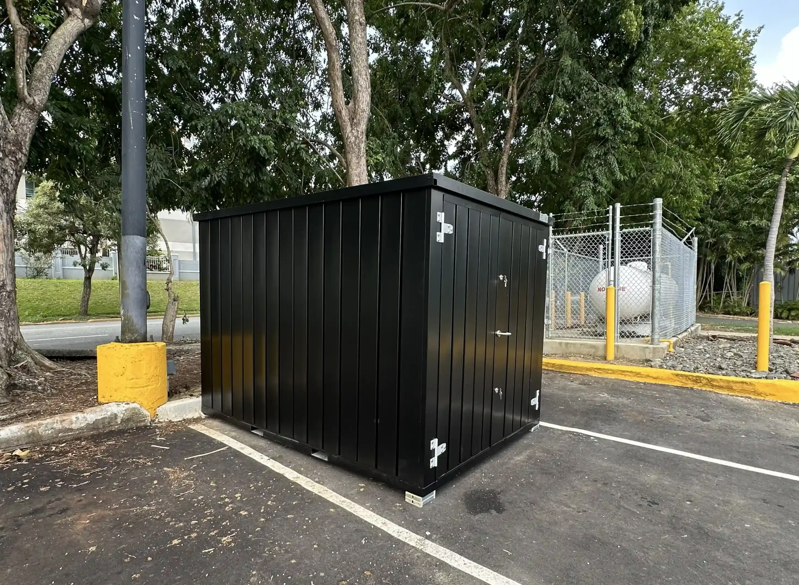 Black mobile storage container in a facility yard near a service area