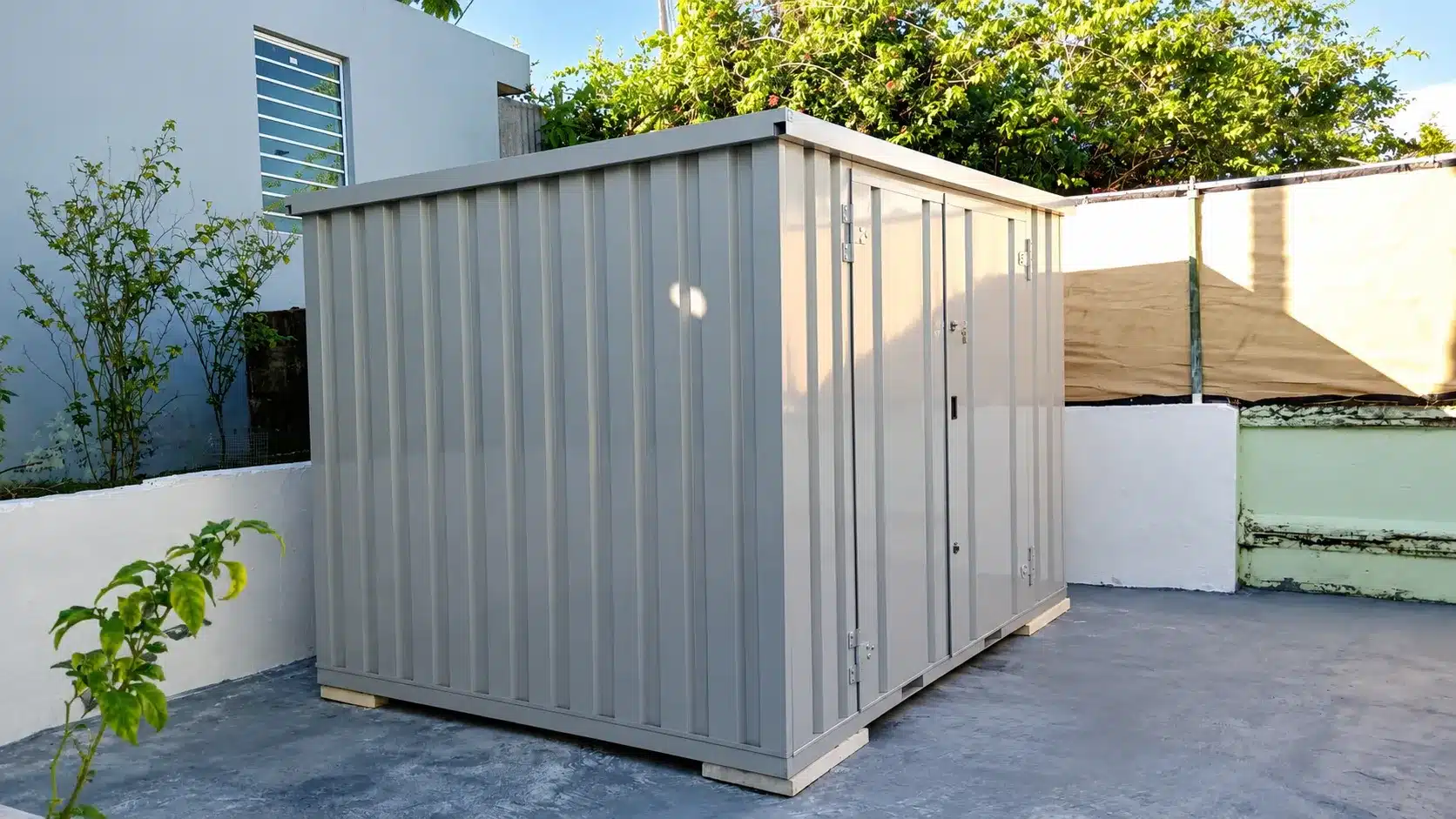Flatpack steel storage container used for tools, maintenance supplies, and equipment at a commercial contractor yard.