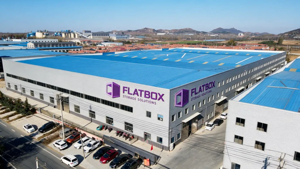 Fixed-end and collapsible flat rack shipping containers at an industrial equipment sales depot.
